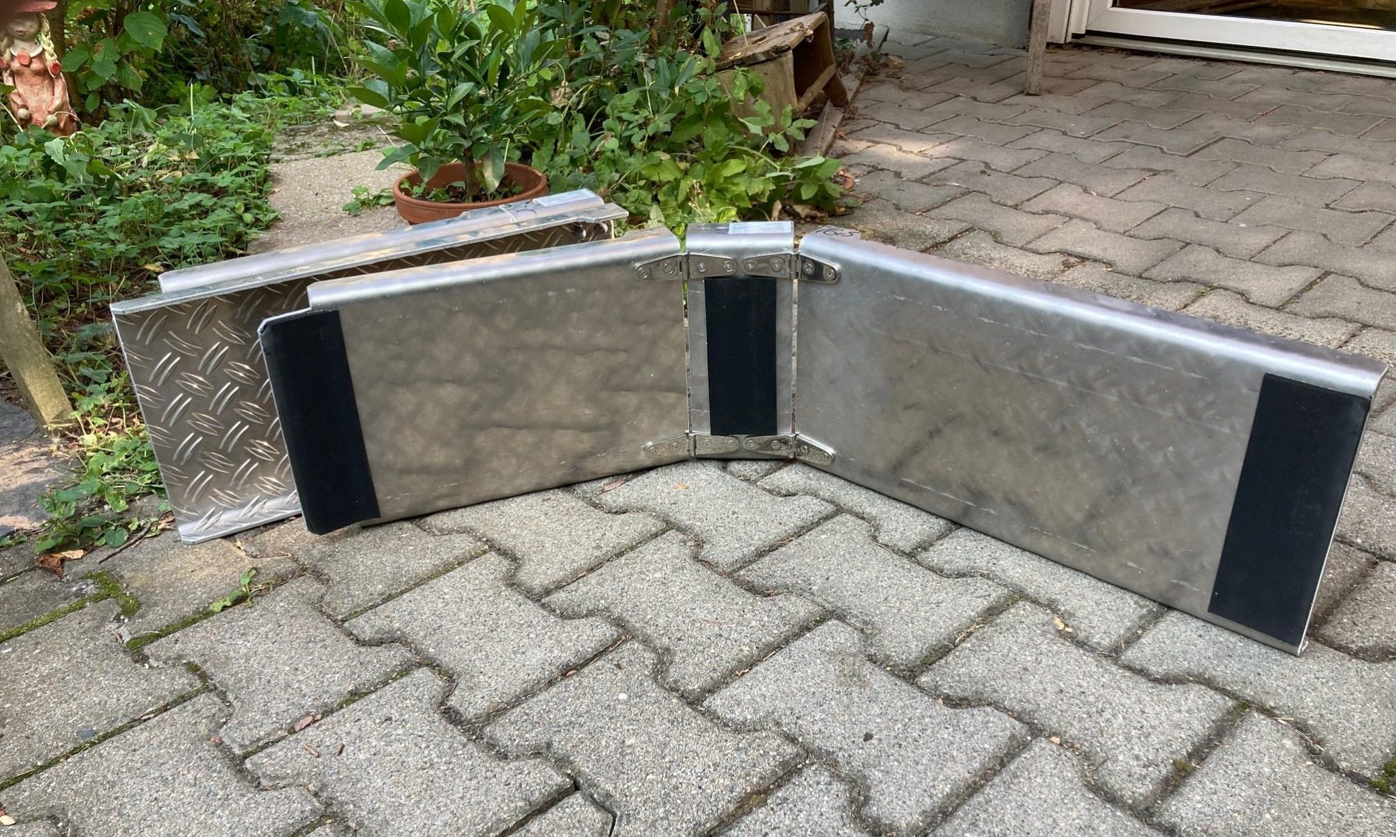 Fest verklebte Antirutschmatten an beiden Enden und in der Mitte der Unterseite an der Rollstuhlrampe.